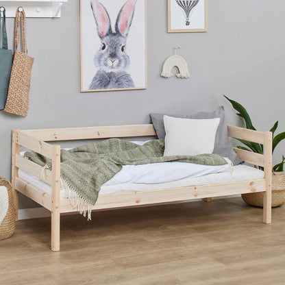 natural wooden frame junior bed in  decorated room, angled view