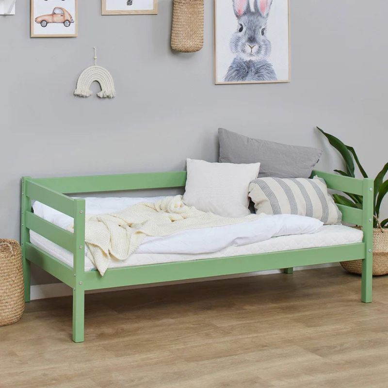 pale green wooden frame junior bed in  decorated room, angled view