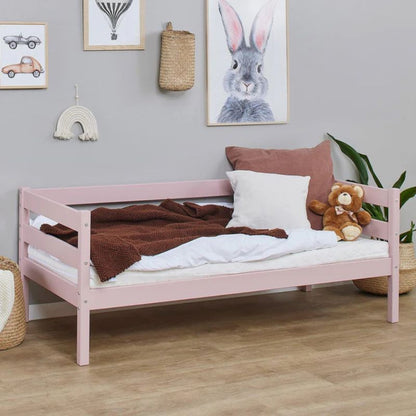 pale rose wooden frame junior bed in  decorated room, angled view