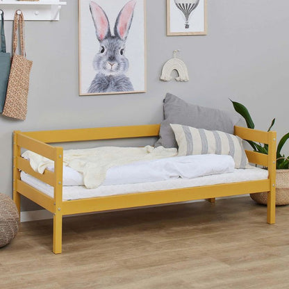 Autumn yellow wooden frame junior bed in  decorated room, angled view