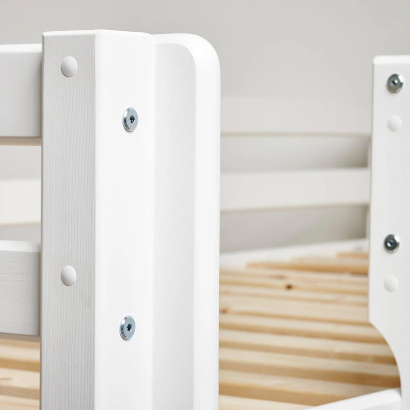 Close-up of a white wooden bed frame with slats.