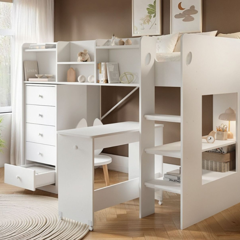 White children's mid sleeper bed with desk and shelves against a beige wall.